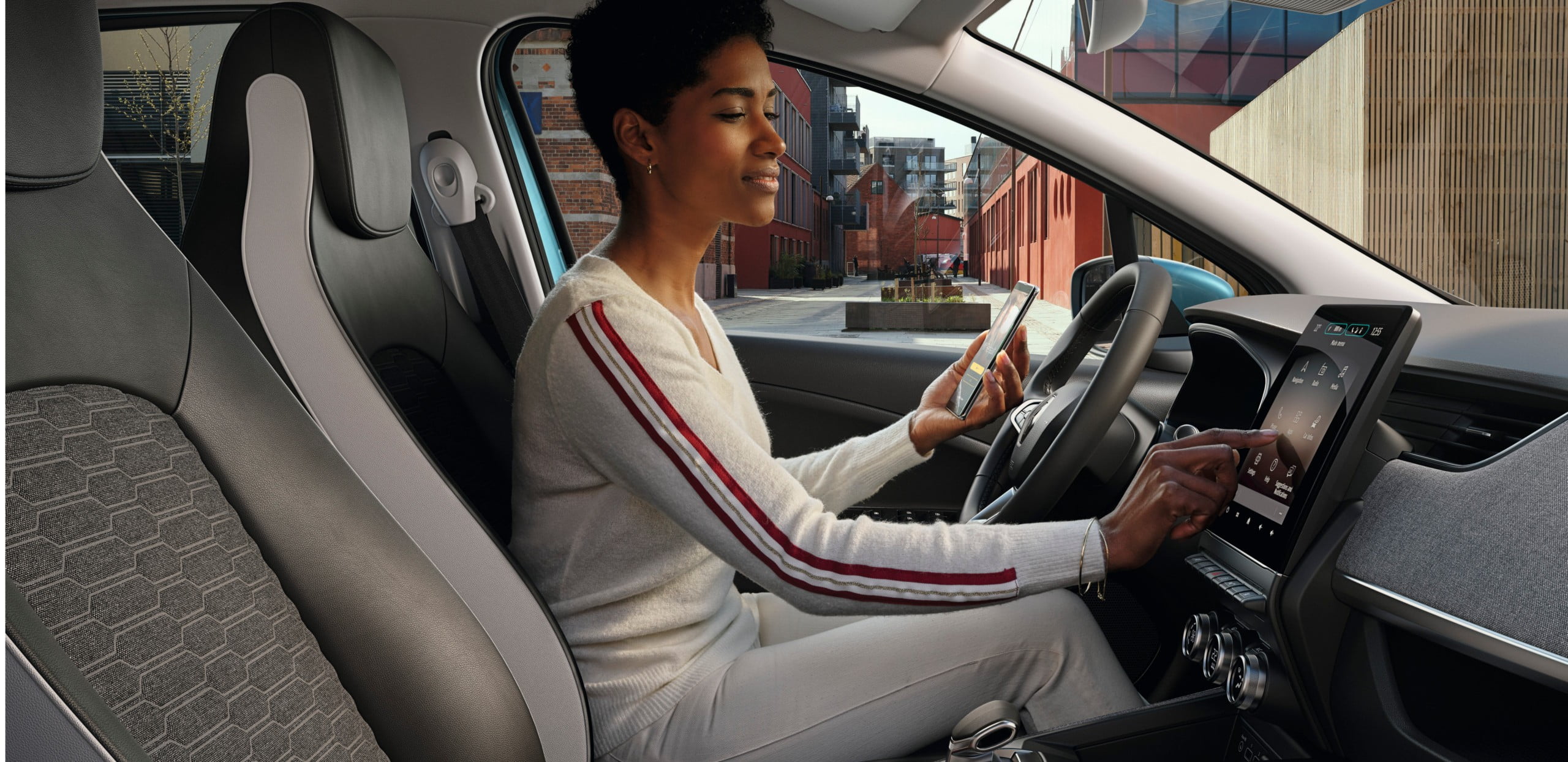Person in Renault ZOE interagiert mit Touchscreen